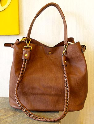 A classic bag in brown leather with a braided handle